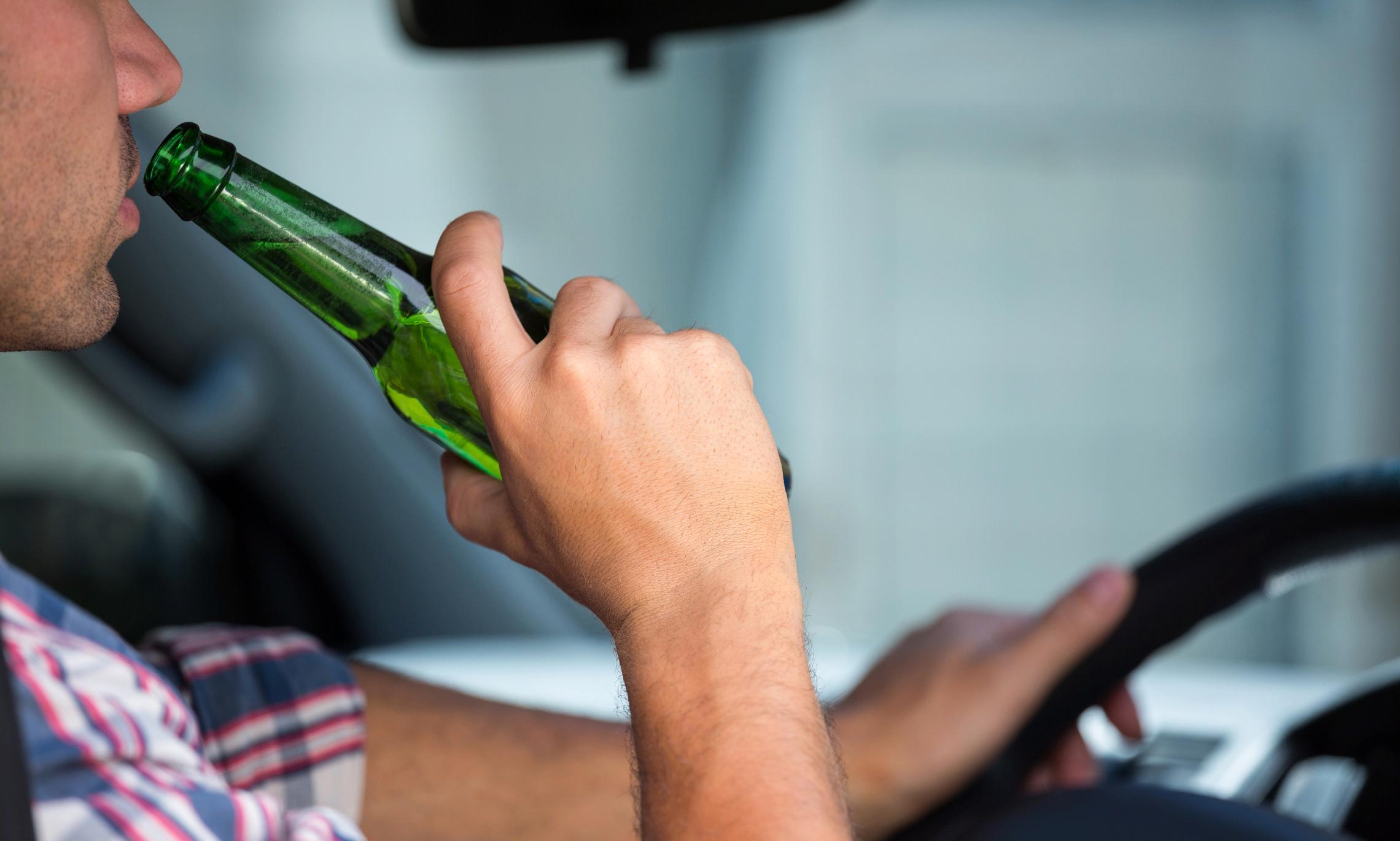 Водитель пьет за рулем. Управление автомобилем в нетрезвом состоянии. Вождение в состоянии алкогольного опьянения.